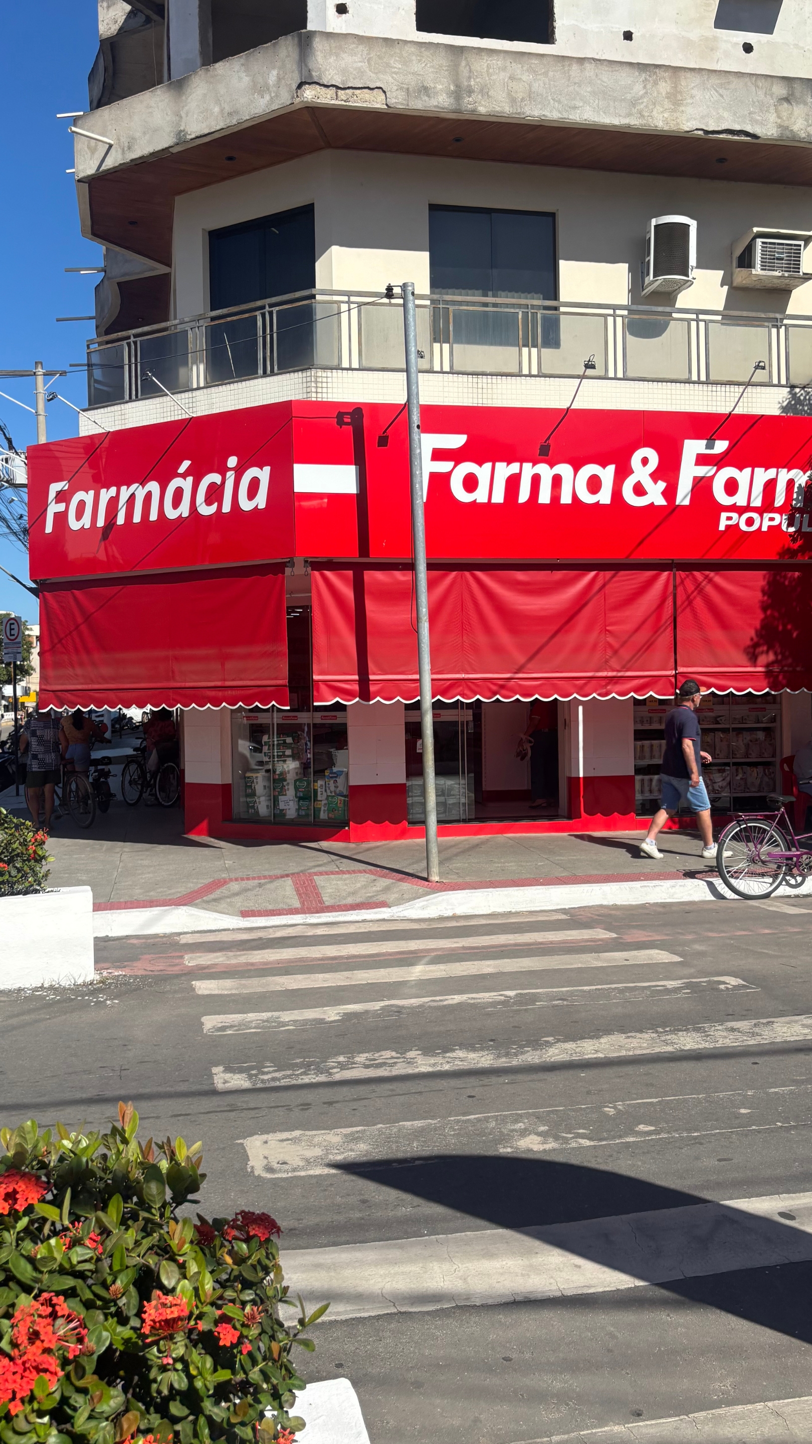 Fachada vermelha da Farma & Farma Popular no centro de Baixo Guandu.