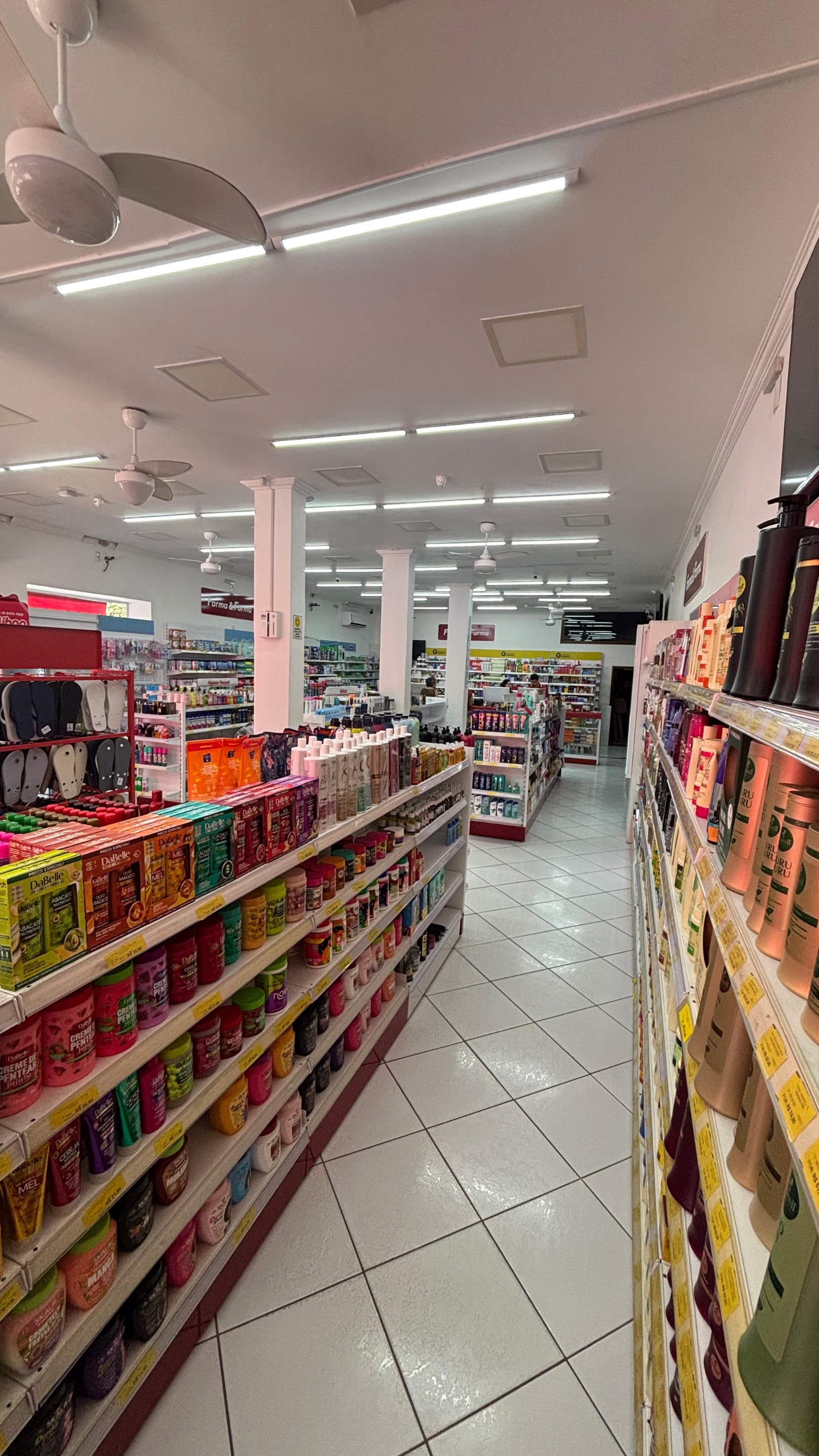 Corredores internos com perfumaria e produtos variados.